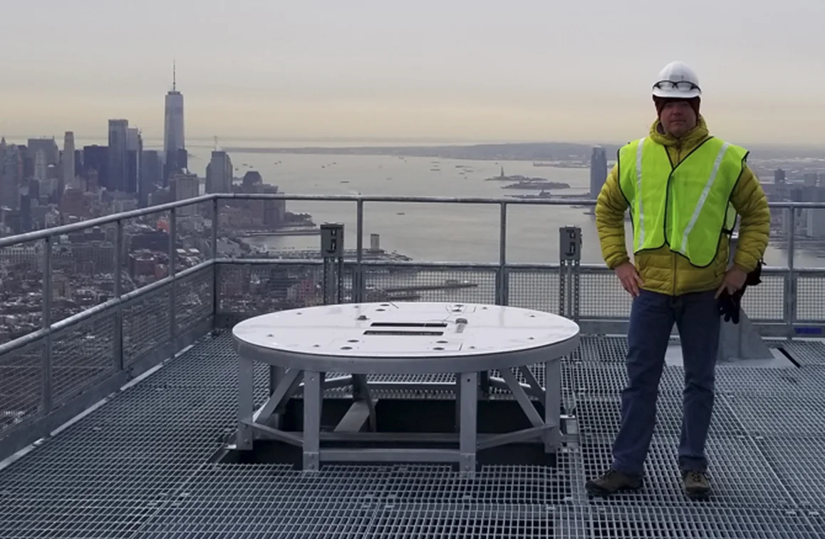 Man in safety gear atop skyscraper