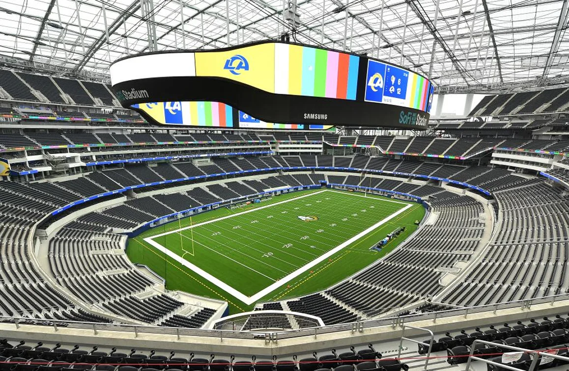 Modern stadium interior with green field.
