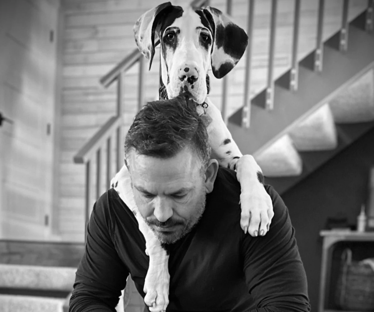 Dog cuddling with a man indoors